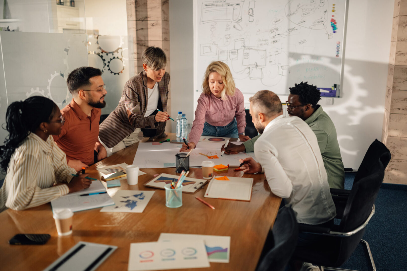 Office workers discussing ideas around table