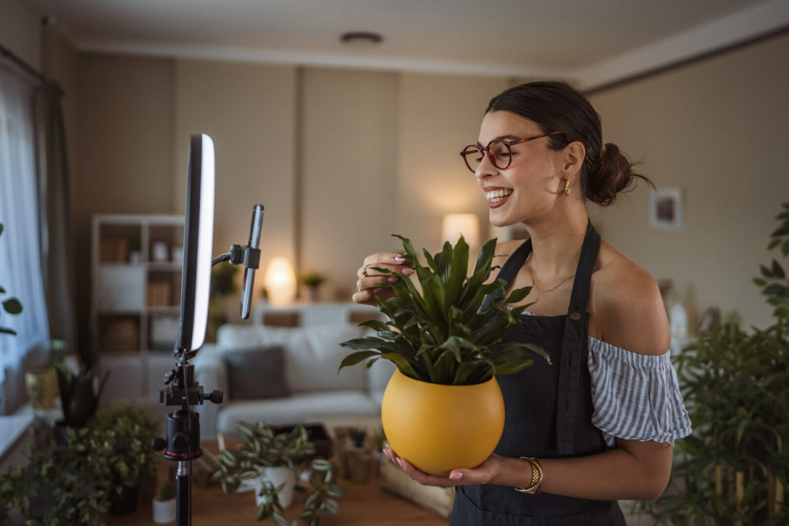 Happy woman recording plant care video